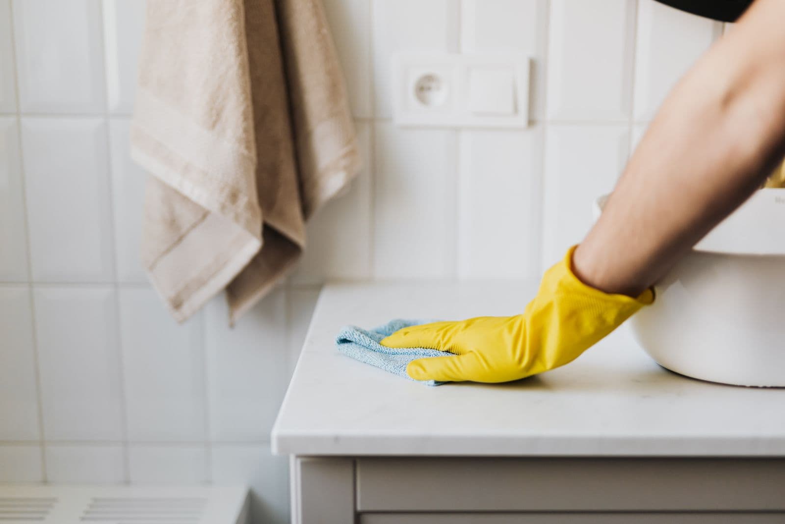 Gloved hands wiping a kitchen counter