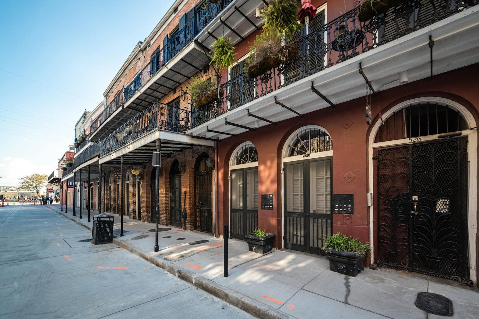 Historic French Quarter buildings in New Orleans with ornate wrought-iron balconies and hanging greenery.