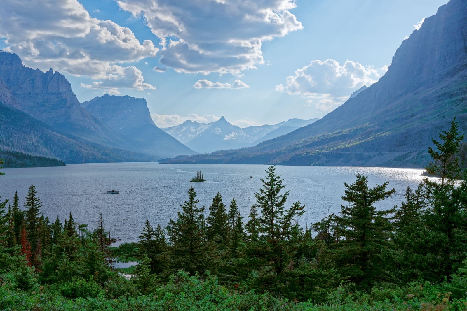 Sunbeams break through clouds over Saint Mary Lake and tiny Wild Goose Island in Glacier National Park.